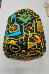 [Patterned fabric doorstop cover lying on its side showing the front and zip on the bottom, with the doorstop inside it]