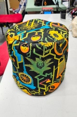 [Patterned fabric doorstop cover showing the front and top, with the doorstop inside it]