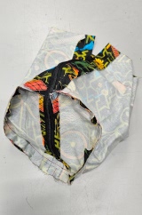 [Patterned fabric doorstop cover without a top section, lying empty inside out showing the zip along the side and bottom]