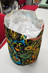 [Patterned fabric doorstop cover from the back showing the zip along the side, open at the top with the white ripstop PVC doorstop inside it]